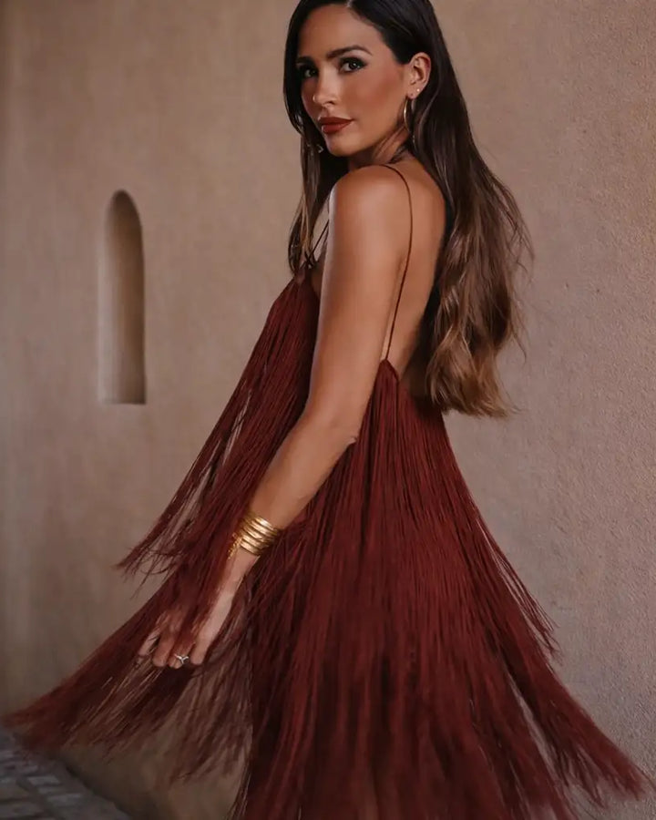 Une robe à franges fluide, d'un bordeaux profond, avec de fines bretelles spaghetti et un design dos nu.